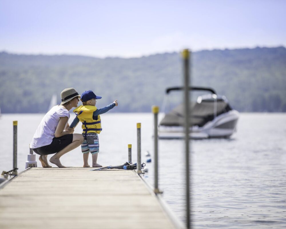 Mother and son standing at the end of a boat dock